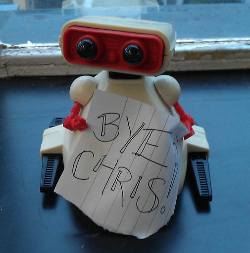 Robot holding a sign saying "Bye Chris"